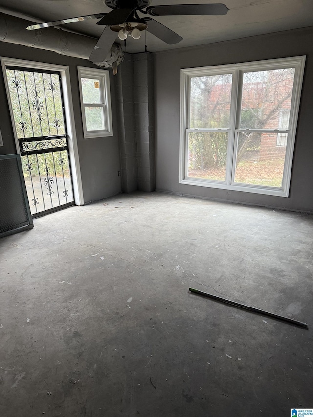 unfurnished room featuring ceiling fan and concrete floors