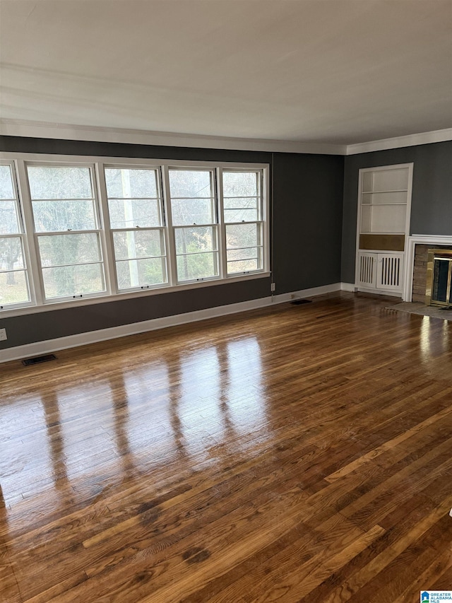 unfurnished room with ornamental molding and dark wood-type flooring