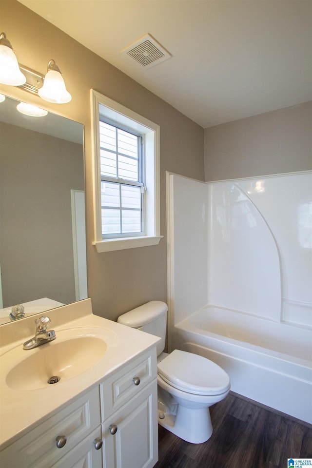 full bathroom featuring hardwood / wood-style flooring, vanity, shower / bathtub combination, and toilet