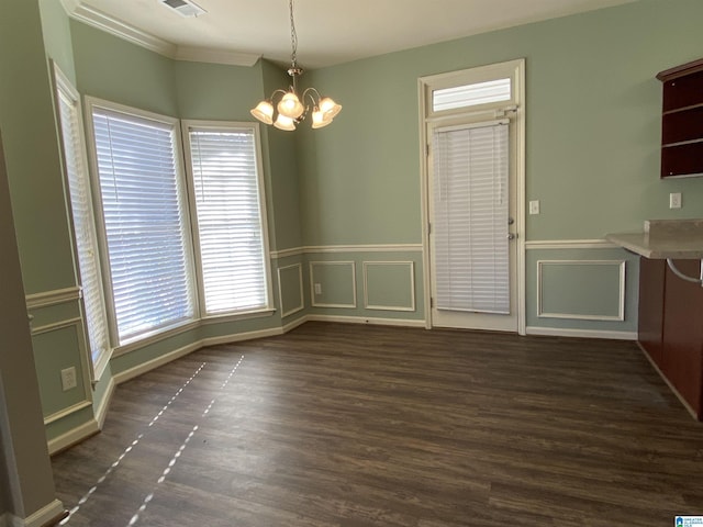 unfurnished dining area featuring a chandelier, dark hardwood / wood-style flooring, and crown molding