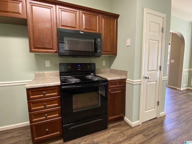 kitchen featuring black appliances and dark hardwood / wood-style floors