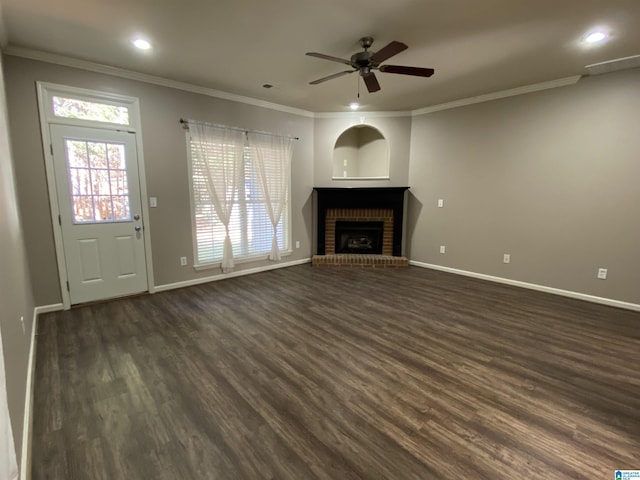 unfurnished living room with ceiling fan, ornamental molding, dark wood-type flooring, and a brick fireplace