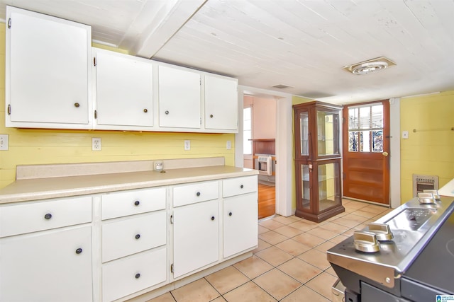 kitchen featuring white cabinetry, light tile patterned flooring, wood ceiling, and wood walls