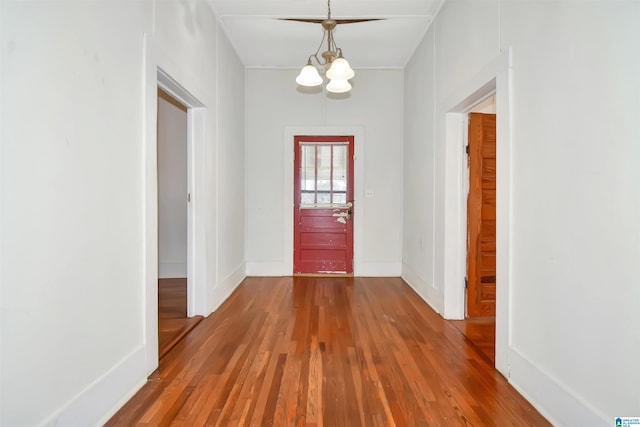 foyer entrance with hardwood / wood-style flooring and an inviting chandelier