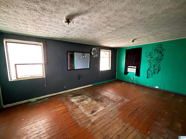 unfurnished room with wood-type flooring and a textured ceiling