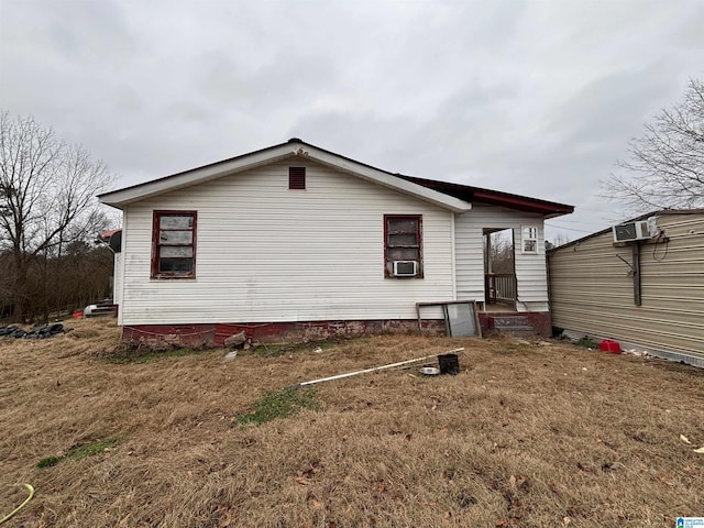 back of property with a wall unit AC and cooling unit