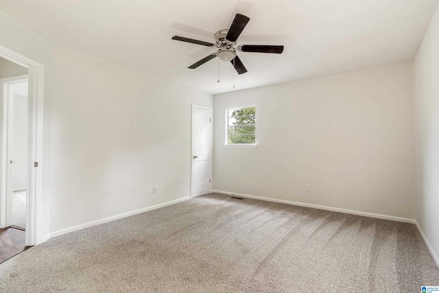 carpeted spare room with ceiling fan