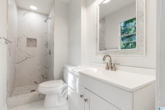 bathroom with vanity, toilet, and a tile shower