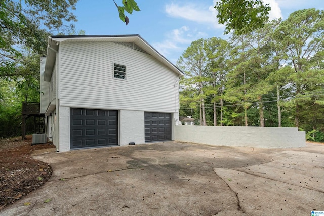 view of side of property featuring central AC unit and a garage