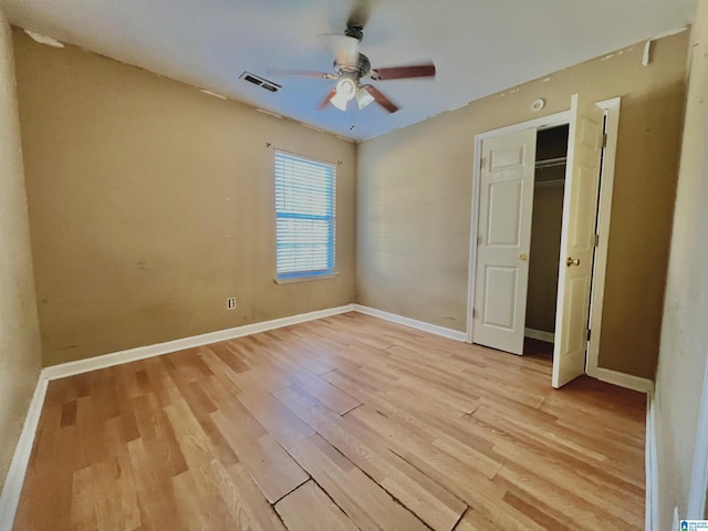 unfurnished bedroom with ceiling fan, a closet, and light wood-type flooring