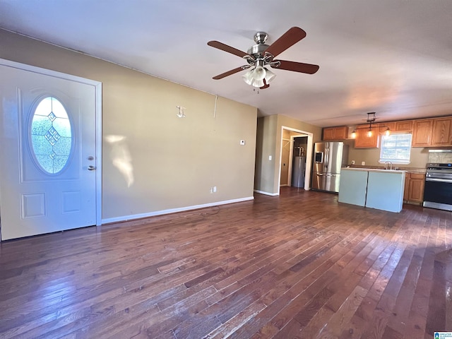 unfurnished living room with dark hardwood / wood-style flooring, ceiling fan, and sink