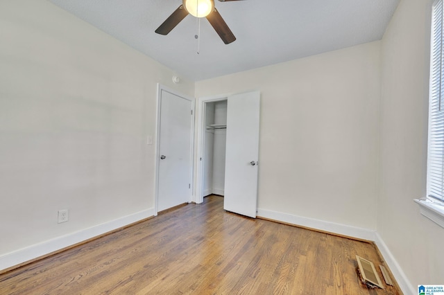 unfurnished bedroom featuring a closet, hardwood / wood-style flooring, and ceiling fan