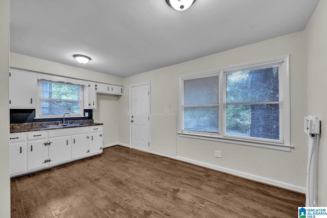 kitchen featuring white cabinetry, sink, and hardwood / wood-style floors