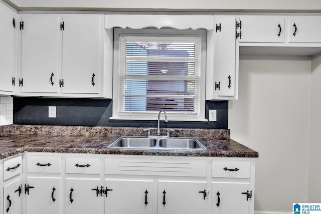 kitchen featuring white cabinets, decorative backsplash, and sink