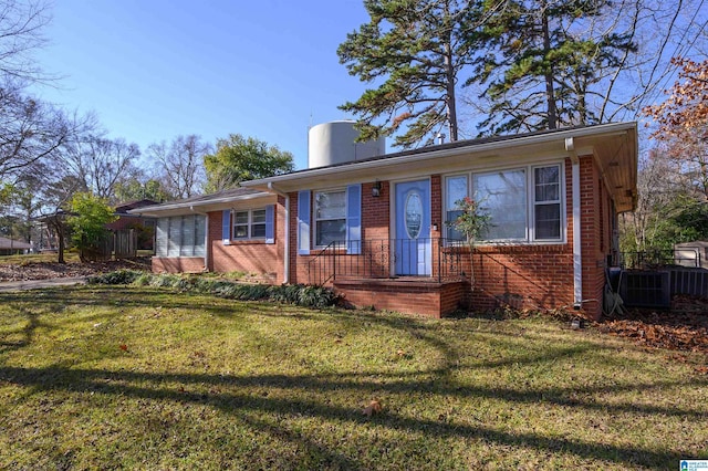 ranch-style house featuring central air condition unit and a front lawn