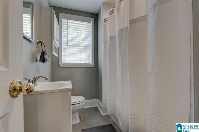 bathroom with tile patterned flooring, vanity, and toilet