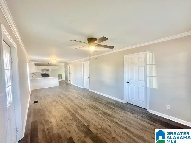 unfurnished living room featuring dark hardwood / wood-style floors, ceiling fan, and ornamental molding