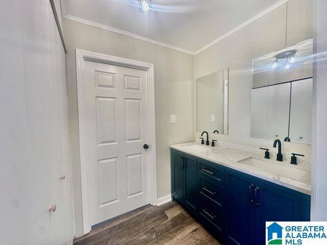 bathroom with vanity, hardwood / wood-style flooring, and ornamental molding