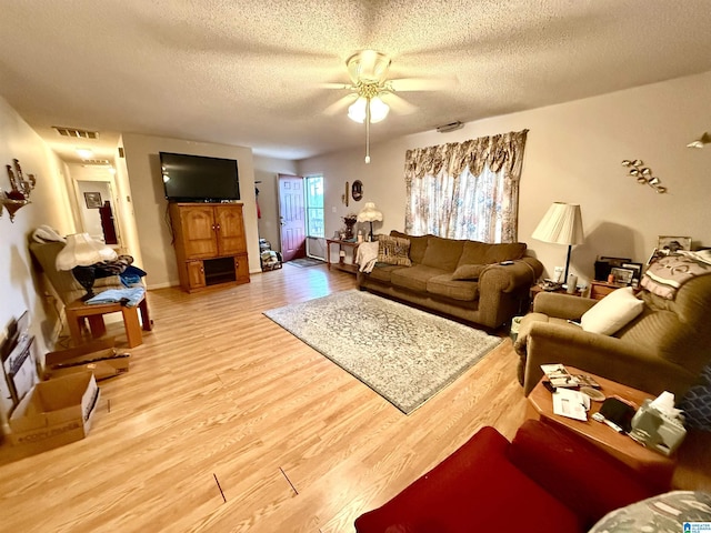 living room featuring ceiling fan, a textured ceiling, and hardwood / wood-style flooring