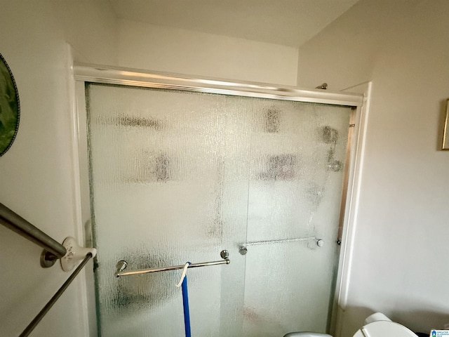 bathroom with an enclosed shower and toilet