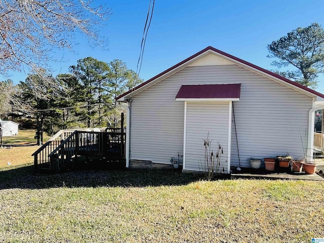 view of side of property featuring a yard and a wooden deck