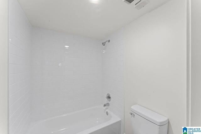 bathroom with tiled shower / bath combo and toilet