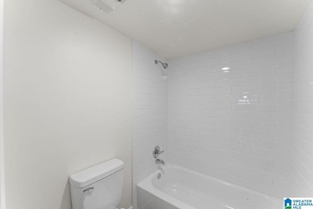 bathroom featuring tiled shower / bath combo and toilet