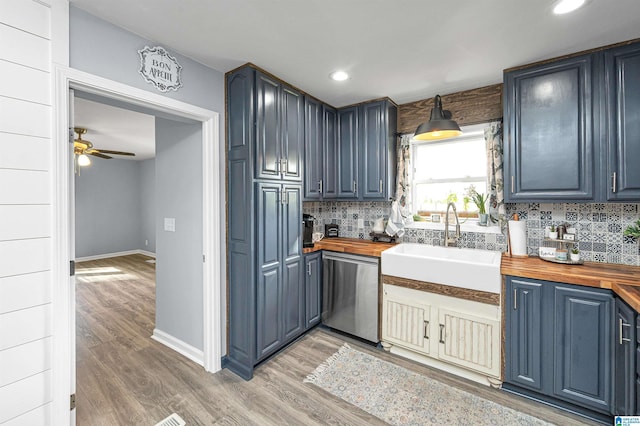 kitchen featuring wood counters, dishwasher, sink, tasteful backsplash, and wood-type flooring