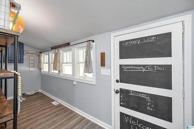 entryway featuring dark hardwood / wood-style floors and vaulted ceiling