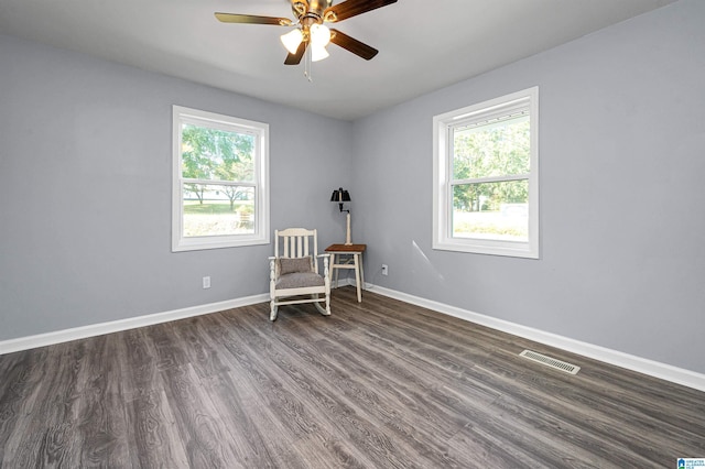 unfurnished room featuring plenty of natural light, dark wood-type flooring, and ceiling fan