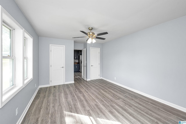 unfurnished bedroom featuring multiple windows, light hardwood / wood-style flooring, and ceiling fan