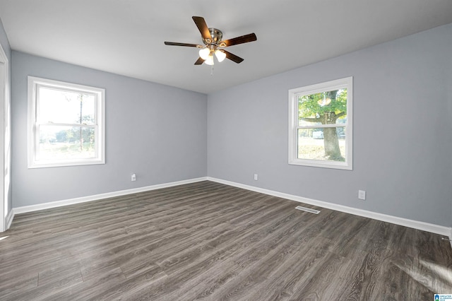 spare room with plenty of natural light, dark wood-type flooring, and ceiling fan