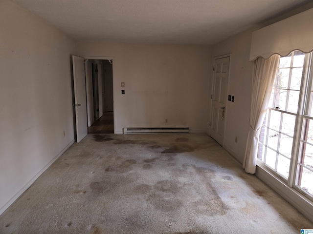 unfurnished room with light colored carpet, plenty of natural light, and a baseboard heating unit