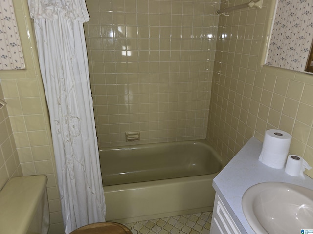 bathroom with vanity, shower / bath combination with curtain, and tile walls