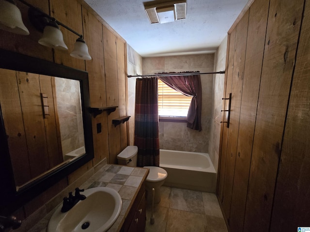 full bathroom featuring toilet, vanity, and shower / tub combo with curtain