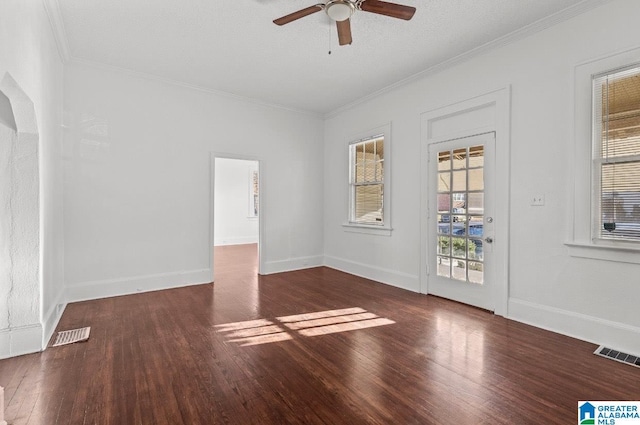 spare room featuring a textured ceiling, dark hardwood / wood-style flooring, ceiling fan, and crown molding