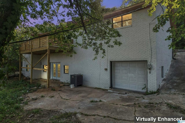 exterior space with a balcony, a garage, and central AC unit