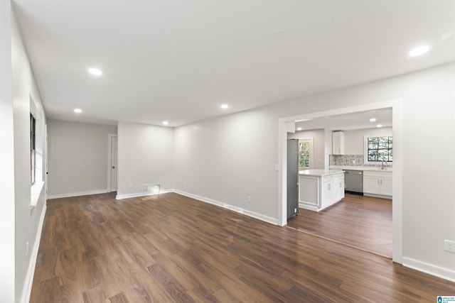 unfurnished living room with dark hardwood / wood-style floors and sink