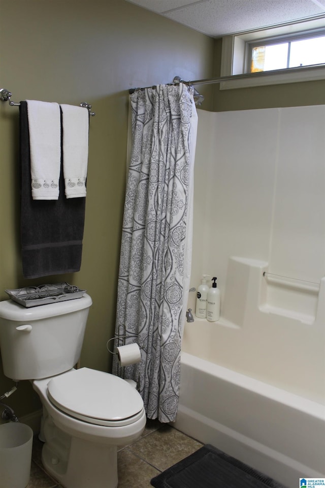 bathroom featuring toilet, shower / bathtub combination with curtain, and tile patterned flooring