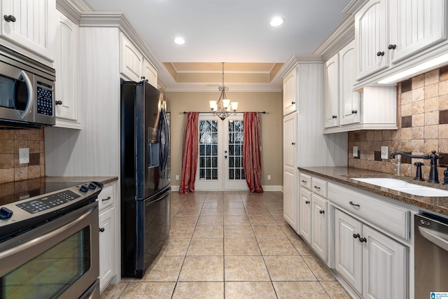 kitchen featuring white cabinetry, sink, stainless steel appliances, and a raised ceiling