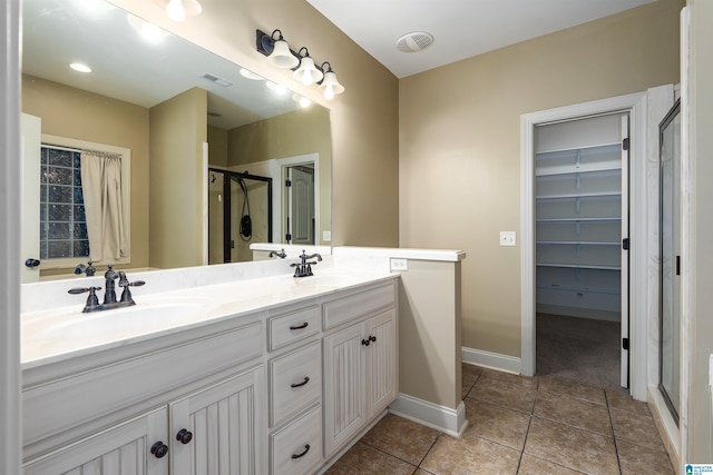 bathroom featuring tile patterned flooring, vanity, and walk in shower