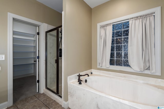 bathroom with independent shower and bath and tile patterned flooring