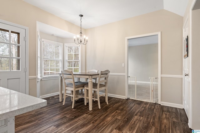 dining room featuring a chandelier, dark hardwood / wood-style floors, and vaulted ceiling