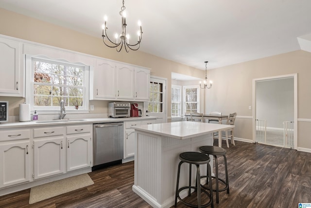 kitchen with stainless steel dishwasher, a kitchen island, sink, white cabinetry, and hanging light fixtures