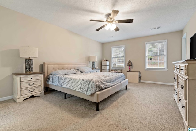 carpeted bedroom featuring ceiling fan and a textured ceiling