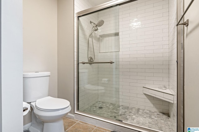 bathroom with tile patterned flooring, toilet, and walk in shower