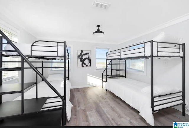 unfurnished bedroom featuring wood-type flooring and ornamental molding