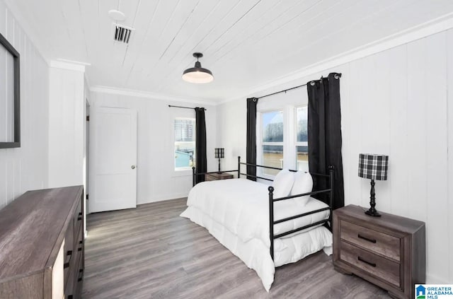 bedroom with hardwood / wood-style floors, wooden ceiling, ornamental molding, and multiple windows