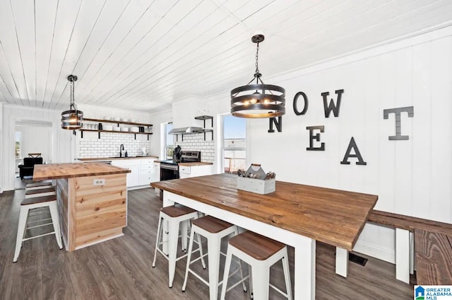 dining area featuring dark hardwood / wood-style flooring, wooden ceiling, and sink