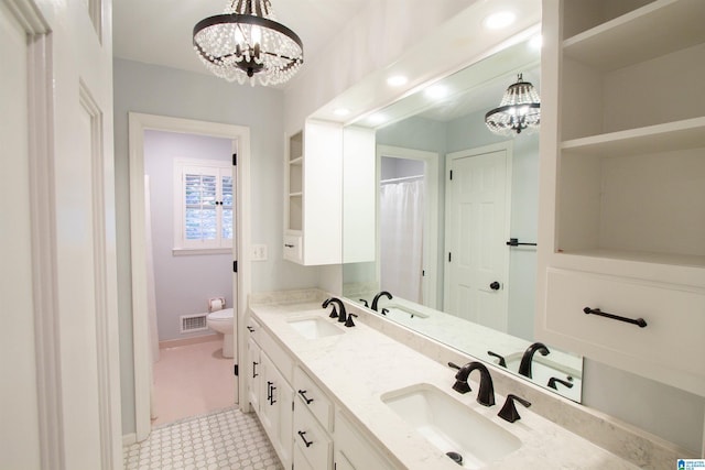 bathroom with vanity, a chandelier, and toilet